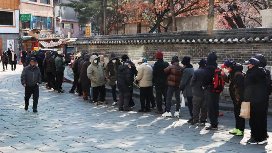 서울 종로구 탑골공원 원각사 노인무료급식소에 어르신들이 점심식사를 위해 줄지어 서 있다.   [연합뉴스]