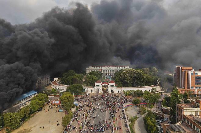 네팔 시위대가 지난 9일 수도 카트만두에서 SNS 금지 및 부패에 대한 항의 시위 중 의회 건물이 불 타자 축하하고 있다. [AP]