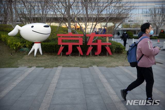 [베이징=AP/뉴시스] 3월27일(현지시간) 중국 베이징에 있는 전자상거래 업체 JD(징둥)닷컴 본사 앞을 한 남성이 지나가고 있다. 2020.06.18.