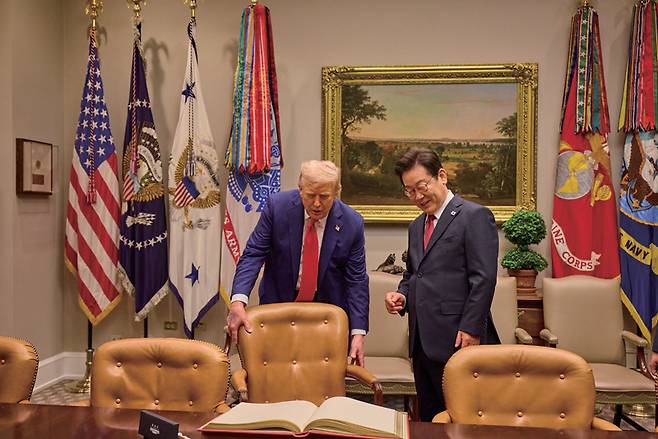 이재명 대통령(오른쪽)이 8월25일 미국 백악관에서 열린 한미 정상회담에 앞서 방명록 서명을 준비하며 도널드 트럼프 미국 대통령의 안내를 받고 있다. ⓒ연합뉴스