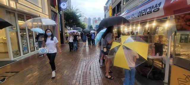 12일 오후 4시께 '제2회 동성로 달콤달달 디저트 페스타'가 열린 대구시 중구 동성로 일대를 찾은 시민들이 우산을 든 채 곳곳에 설치된 부스를 살펴보며 축제를 즐기고 있다. 권영진 기자