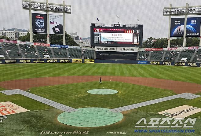 NC-LG전이 예정된 12일 잠실구장에 비가 내려 방수포가 깔리고 있다. 잠실=권인하 기자