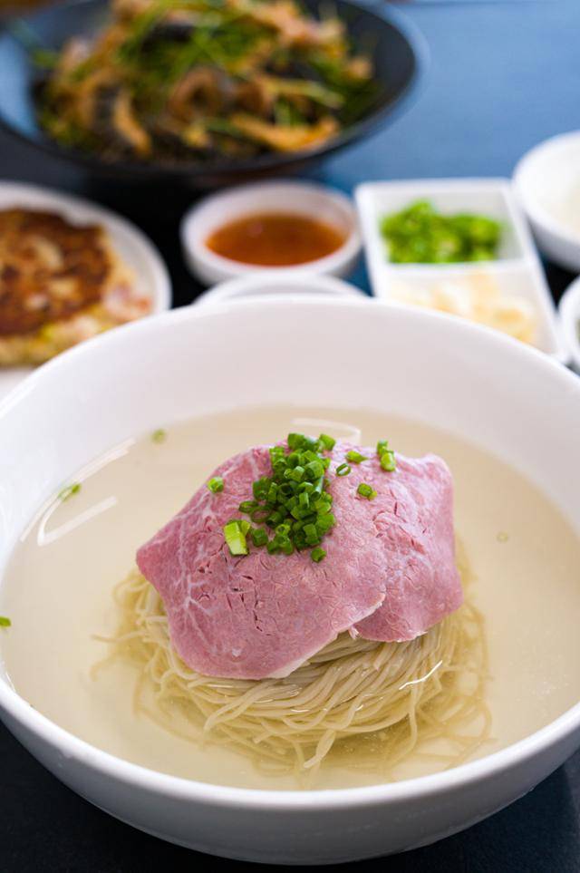 서울 강남구에 위치한 냉면집 '우주옥'의 냉면. 홍두깨살을 수비드 방식으로 조리해 면 위에 올린 분홍빛 고명이 상징이다. 허재훈 셰프는 "냉면은 6, 7도일 때 먹으면 가장 맛있는데, 그러면 열에 아홉은 미지근하다는 반응이라 육수 냉장고 온도인 3.5도로 제공하고 있다"며 "바로 후루룩 드시기보다는 육향이 서서히 올라오는 걸 느끼며 즐기시길 권한다"고 말했다. 장준우 제공