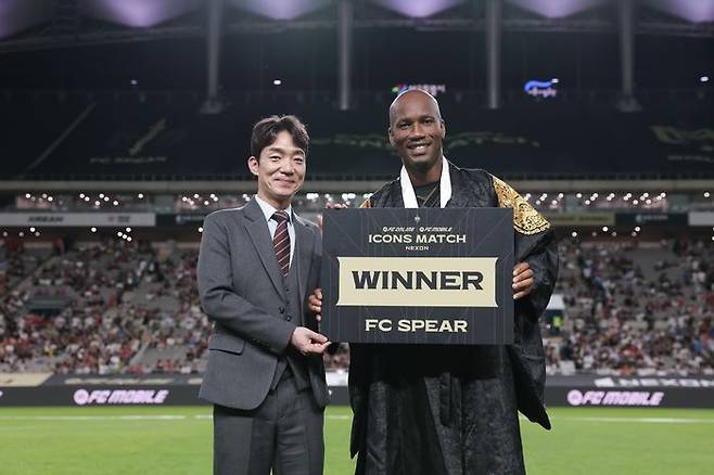 박정무 넥슨 사업부사장과 디디에 드로그바 FC스피어팀 주장이 13일 서울월드컵경기장에서 열린 '2025 아이콘매치: 창의 귀환, 반격의 시작'에서 승리 세리머니 후 기념 사진을 촬영하고 있다.ⓒ데일리안 이주은 기