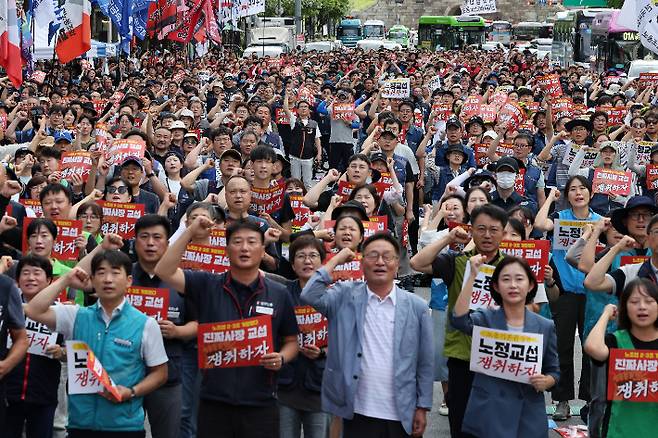 전국민주노동조합총연맹(민주노총) 조합원들이 13일 서울 중구 시청역 인근에서 결의대회를 열고 노동자 노동기본권과 노정교섭 쟁취 등을 촉구하며 구호를 외치고 있다. 연합뉴스