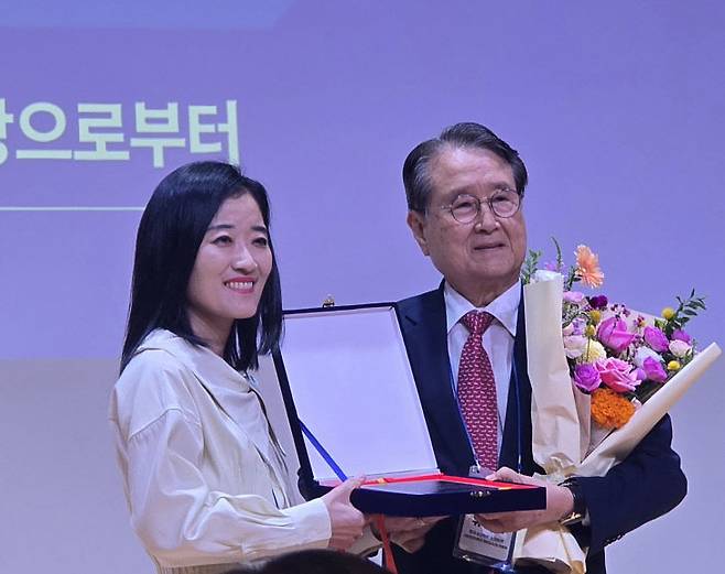 이수진 회장이 유장희 초대 회장에게 공로패와 꽃다발을 증정하고 있다,                                                                                                   사진 한성일 기자
