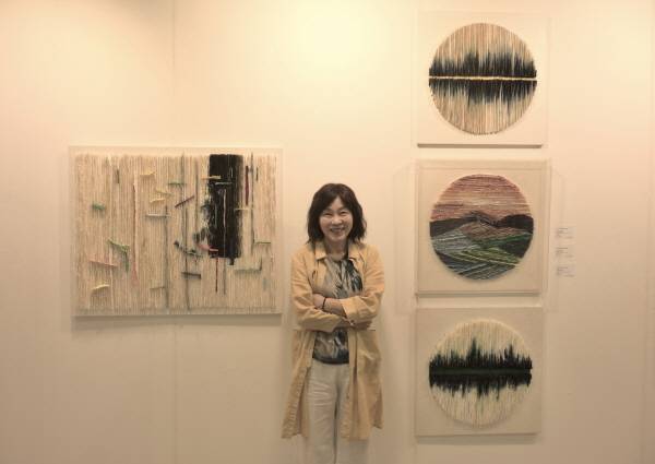 '제12회 경남국제아트페어' 갤러리거제 전시관에서 정영숙 작가가 자신의 작품과 함께 기념촬영을 하고 있다.