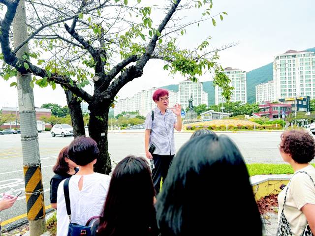 김탁환 소설가가 독자와의 걷기 행사에서 진해 북원광장에 세워진 이순신 장군의 동상을 소개하고 있다.