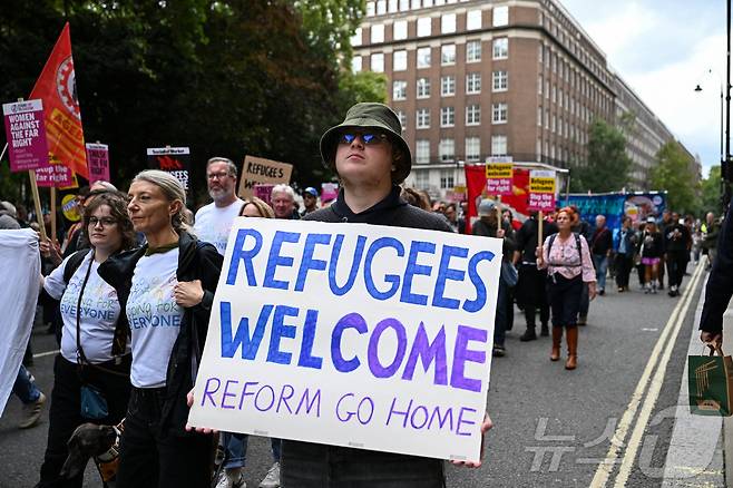 13일(현지시간) 영국 런던에서 반이민 극우 집회에 맞서 '인종주의 반대' 시위대가 행진하고 있다. ⓒ 로이터=뉴스1
