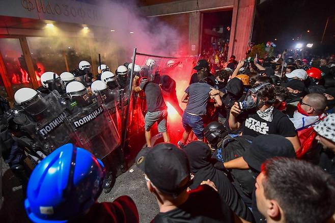 지난 5일 세르비아 제2 도시 노비사드에서 수천 명의 반정부 시위대가 거리를 행진하자 경찰이 최루탄과 섬광탄을 쏘며 대치하고 있다. 시위는 작년 11월 16명의 목숨을 앗아간 노비사드역 지붕 붕괴 참사로 촉발된 것이다. 정부의 구조적 부패 의혹이 제기되자 시위대는 알렉산다르 부치치 대통령의 퇴진과 조기 총선을 요구하고 있다. /AFP 연합뉴스