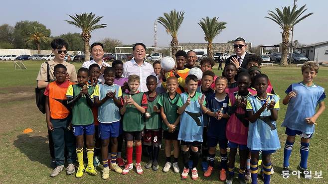 11일(현지 시각) 아프리카 나미비아 수도 빈트후크의 축구경기장 ‘파이어니어스파크’를 찾은 김종훈 전북도 경제부지사(뒷줄 왼쪽에서 세 번째)가 이달 말로 예정된 전북 유소년 축구팀과의 친선 경기를 위해 꾸려진 대표팀 선수들을 격려한 뒤 기념사진을 찍고 있다. 나미비아 빈트후크=박영민 기자 minpress@donga.com