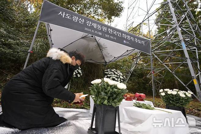 [사도=AP/뉴시스] 사진은 지난해 11월 25일 일본 니가타현 사도 광산 인근 조선인 기숙사 터에서 일본 정부와 별도로 사도 광산 강제동원 한국인 희생자 추도식이 열려 한 관계자가 제단을 준비하고 있다. 2024.11.25.