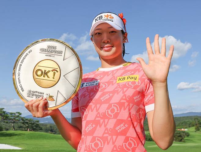 방신실이 14일 한국여자프로골프(KLPGA)투어 OK저축은행 읏맨 오픈에서 우승한 뒤 우승 트로피를 들어 보이고 있다. 왼손으로는 통산 승수 5승을 표현하고 있다. KLPGA투어 제공