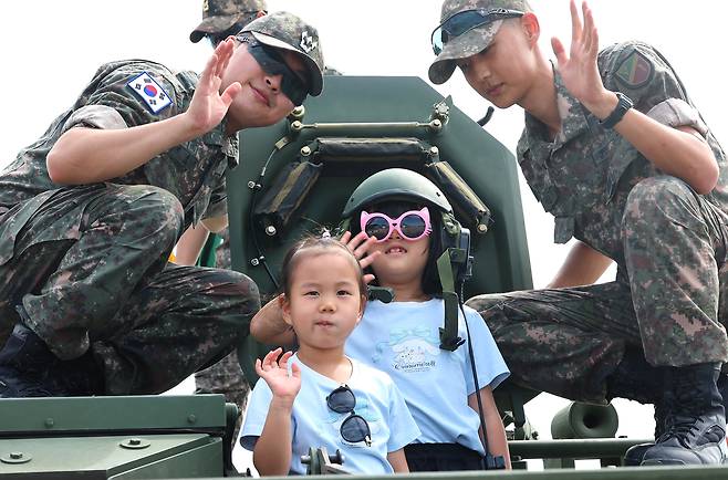 Children pose for photos with soldiers on an armed vehicle in an event to commemorate the 75th anniversary of Operation Chromite in Jung District, Incheon, on Sept. 14. [YONHAP]