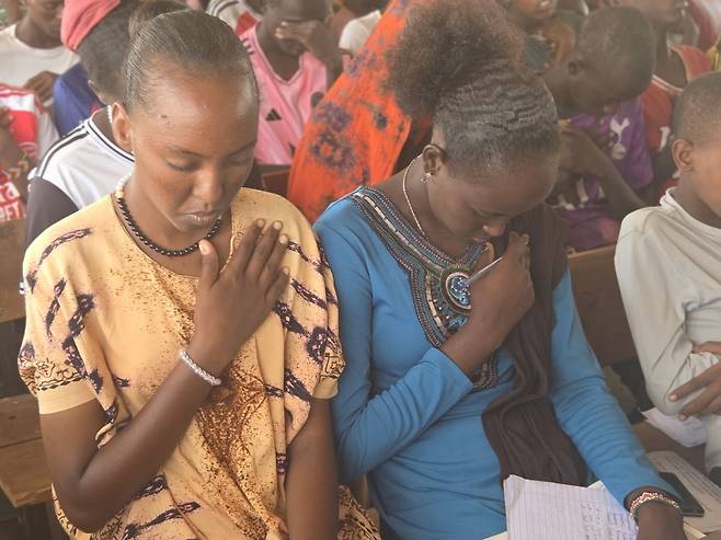 나씨보 미르기찬이 친구와 함께 주일 예배 때 기도하고 있는 모습.