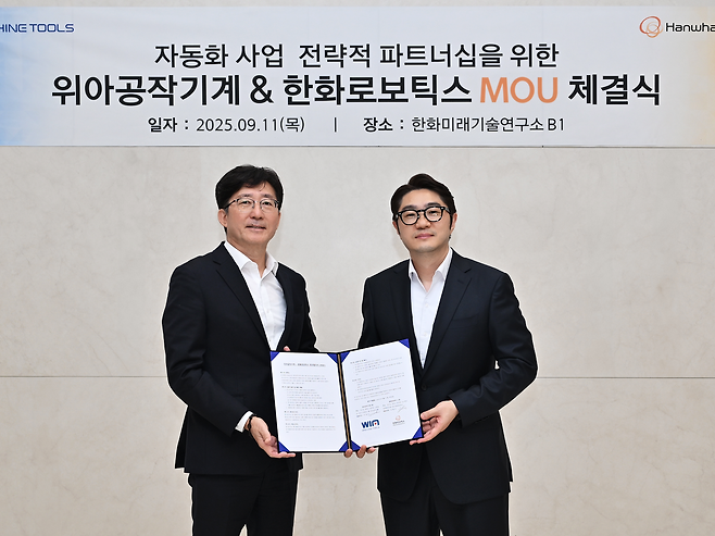 주재진(왼쪽) 위아공작기계와 정병찬 한화로보틱스 대표가 업무협약식 직후 기념촬영을 하고 있다.  [위아공작기계 제공]