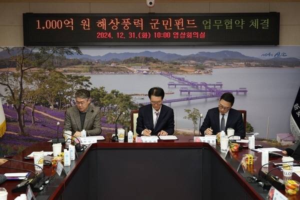 지난 2024년 12월31일 신안군청 영상회의실에서 이용안 신안우이해상풍력㈜ 대표, 박우량 당시 신안군수, 윤태환 ㈜루트에너지 대표가 1000억 원 해상풍력 군민펀드 조성 업무협약서에 서명하고 있다. 신안군 제공