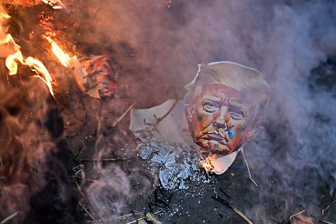 지난달 13일(현지 시각) 인도 콜카타에서 미국의 관세 부과에 항의하는 시위대가 도널드 트럼프 미국 대통령의 허수아비를 불태우고 있다. / AFP=연합