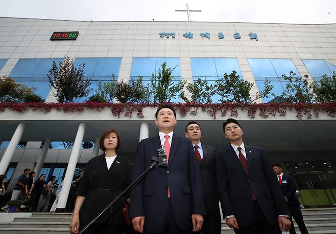 장동혁 국민의힘 대표가 14일 경찰에 최근 구속된 손현보 목사가 담임 목사로 있는 부산 강서구 세계로교회 예배에 참석하며 취재진 질문에 답하고 있다. [사진 뉴스1]