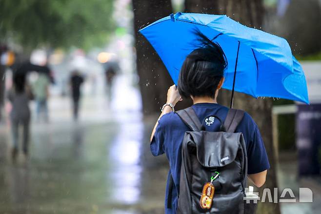 [서울=뉴시스] 정병혁 기자 = 16일 서울 중구 을지로입구역 인근에서 한 시민이 우산을 붙잡고 이동하고 있다. 2025.09.16. jhope@newsis.com