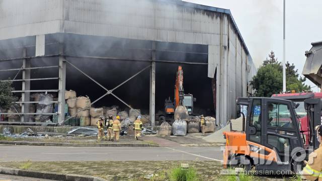 ▲15일 오전 전남 광양시 도이동 물류창고 화재 현장에서 굴착기가 창고 내부에 있는 금속성 폐기물이 담긴 톤백을 외부로 옮기고 있다.2025.9.15.ⓒ프레시안(지정운)