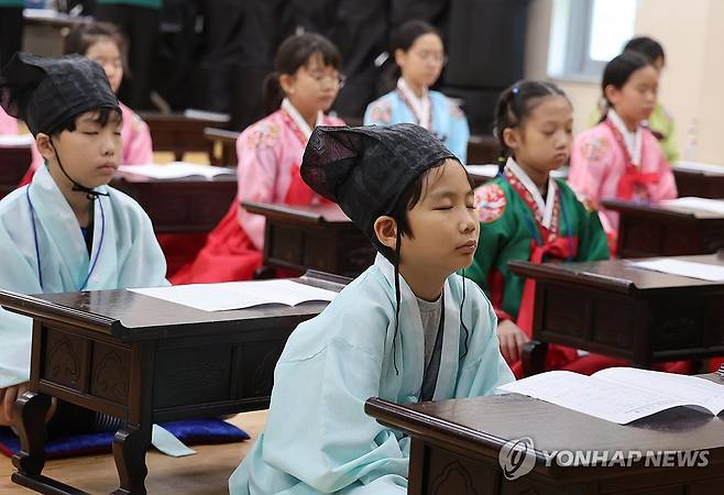 여름방학 초등학생 전통문화 체험교실, 명상 중 (부산=연합뉴스) 강선배 기자 = 28일 부산 동래구 충렬사 안락서원 교육회관에서 열린 '2025년도 여름방학 초등학생 전통문화 체험교실'에 참가한 학생들이 한복을 곱게 차려입고 전통예절을 배우고 있다. 2025.7.28 sbkang@yna.co.kr