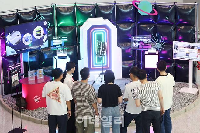슈퍼스타트 데이 2025에서 LG 직원들이 LG의 카메라 모듈, 배터리 셀, 통신 모듈용 안테나가 탑재된 무인탐사연구소의 달 탐사 로버에 대한 설명을 듣고있다. (사진=LG)