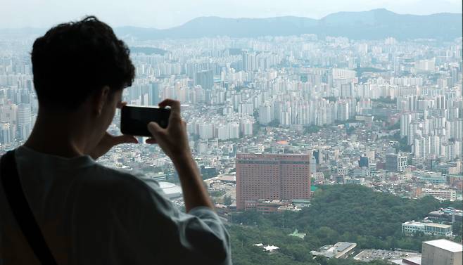 지난 7월 14일 서울 남산 N서울타워에서 한 외국인 관광객이 서울 시내 아파트단지 전경을 살펴보고 있다./연합뉴스