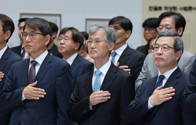 조희대 대법원장(가운데)이 12일 오전 서울 서초구 대법원에서 열린 2025 대한민국 법원의 날 기념식에서 국기에 대한 경례를 하고 있다. 뉴스1