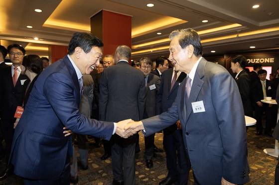 Lotte Group Chairman Shin Dong-bin, left, shakes hands with JoongAng Holdings Chairman Hong Seok-hyun ahead of the JoongAng Ilbo’s 60th anniversary ceremony at Lotte Hotel in Jung District, central Seoul, on Sept. 17. [JUN MIN-KYU]