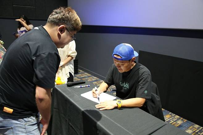 밀알복지재단 굿윌스토어의 장애 직원이 지난 15일 서울 송파구 롯데시네마에서 배우 양동근씨의 사인을 받고 있다. 밀알복지재단 제공