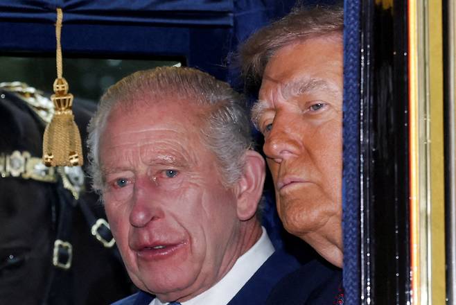 찰스 3세 영국 국왕과 도널드 트럼프 미국 대통령이 17일(현지시간) 영국 왕실의 상징물로 금도금 장식이 된 화려한 ‘아일랜드 국가 마차’에 함께 올라 이동하고 있다. [AFP]