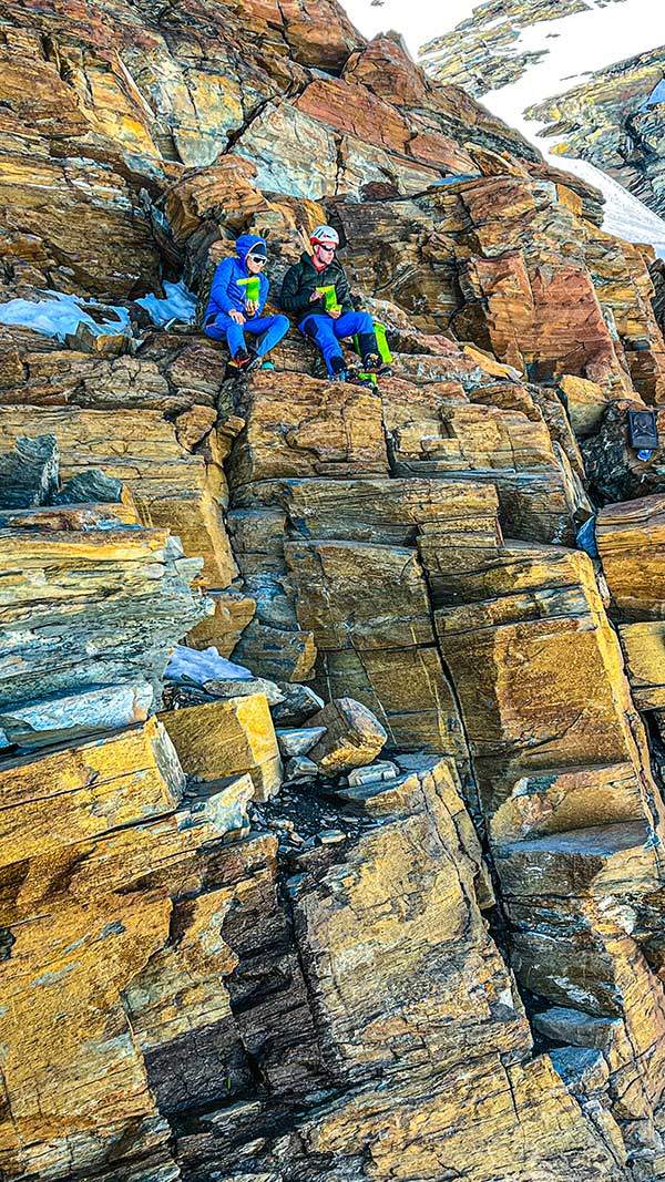 로시 에 볼란테 비박산장 인근의 바위벽 중턱에서 등반가 두 명이 앉아서 쉬고 있다.