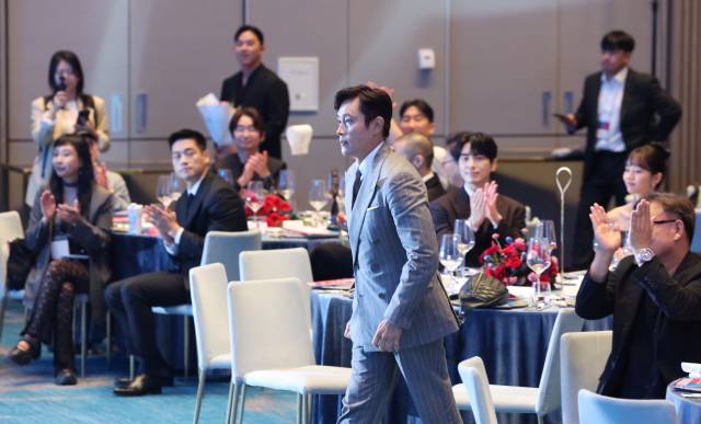 2025 부일영화상이 18일 부산 해운대구 시그니엘 부산 그랜드볼룸에서 열렸다. 남우주연상을 받은 이병헌이 동료 영화인들의 축하를 받으며 무대로 오르고 있다. 정종회 기자 jjh@