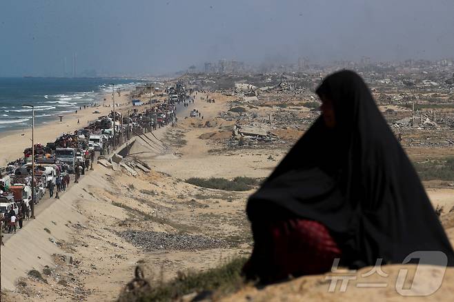 17일(현지시간) 한 여성이 이스라엘의 군사 작전으로 가자지구 북부에서 남쪽으로 이동하는 팔레스타인 피란민들을 바라보고 있다. 2025.09.17. ⓒ 로이터=뉴스1 ⓒ News1 윤다정 기자