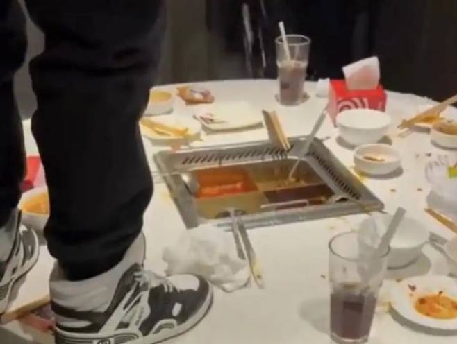 한 남성이 훠궈 음식점인 하이디라오에서 냄비에 소변을 보고 있는 모습./ 웨이보