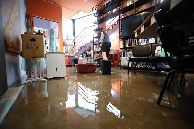 강원 원주의 한 상가주택에서 주민이 침수 피해를 수습하고 있다. /뉴스1