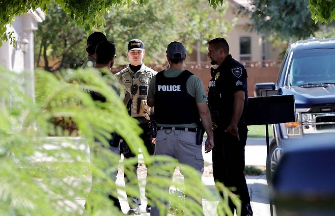 12일(현지 시각) 미국 유타주 워싱턴시의 한 주택 앞에 워싱턴 카운티 보안관실 부보안관이 워싱턴시 경찰관들과 함께 서 있다. 이 주택은 찰리 커크를 총격 살해한 혐의를 받는 용의자 타일러 로빈슨과 관련된 곳이다. / 로이터=연합