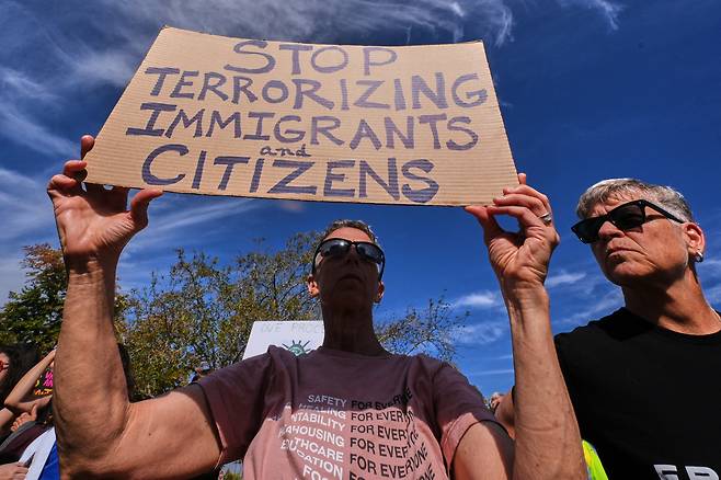 16일(현지 시각) 미국 매사추세츠주 벌링턴 이민세관집행국 지역사무소 밖에 시위대가 '이민자와 시민에게 테러를 멈추라'는 피켓을 들고 있다. /AP=연합뉴스