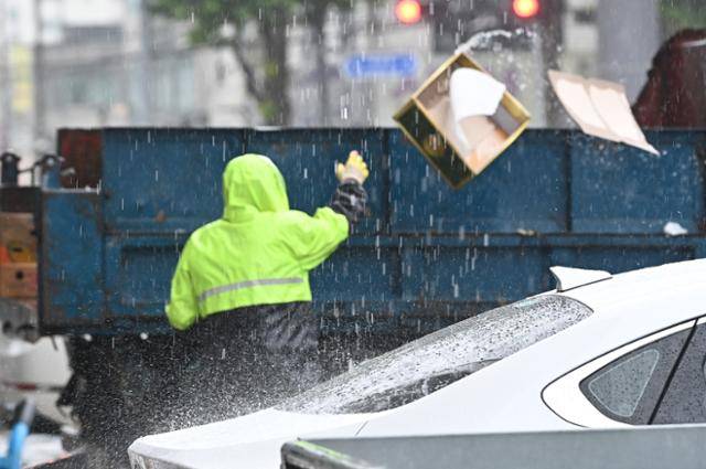 수도권 지역에 호우주의보가 발효된 17일 경기 수원시 권선구 농수산물도매시장에서 환경미화원이 비를 맞으며 종이박스를 차량에 싣고 있다. 사진은 기사 내용과 관련 없음. 뉴시스