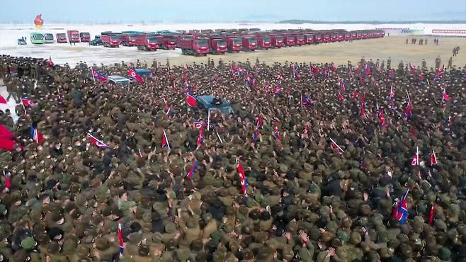 2022년 2월 함경남도 함주군 연포온실농장 착공식 직후 건설에 투입될 군인들이 김정은 위원장이 탄 차를 에워싸고 환호하고 있다.