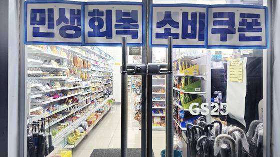 지난 16일 저녁 서울 금천구에 위치한 한 GS25 매장. 출입구에는 ‘민생회복 소비쿠폰’이라고 적힌 현수막이 걸려있다. 노유림 기자