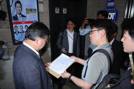 국민의힘 당원명부 압수수색에 나선 김건희특검 수사관들이 18일 서울 여의도 중앙당사에서 국민의힘 변호사에게 영장을 제시하고 있다. 뉴스1