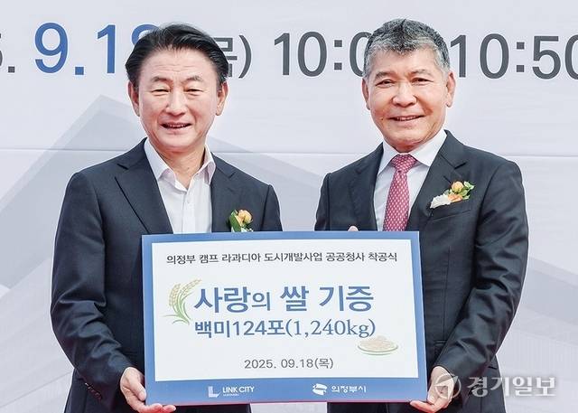 김완식 더랜드그룹 회장(오른쪽)이 김동근 의정부시장에게 백미 124포(1천240㎏)를 기증하고 있다. 홍기웅기자