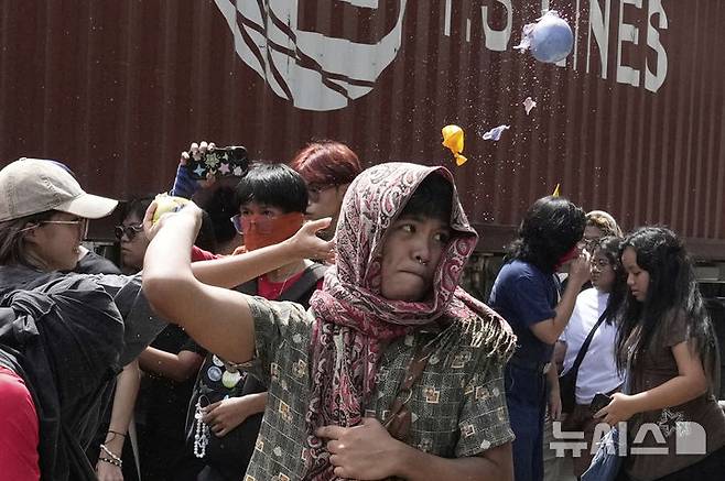 Protesters throw balloons f[마닐라=AP/뉴시스] 필리핀 마닐라 시민들이 4일 국회의원과 건설업체의 홍수 방지 비용 유용 등 부패에 항의하는 시위를 벌이고 있다. 일부 시위대는 오물이 든 풍선을 공공사업부 건물에 던지기도 했다. 2025.09.18.