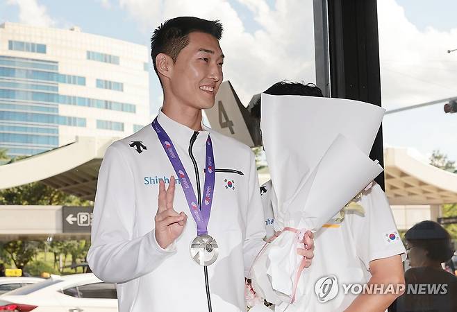 환하게 웃는 '스마일 점퍼' 우상혁 (서울=연합뉴스) 김인철 기자 = 2025 도쿄 세계육상선수권대회 남자 높이뛰기 결선에서 은메달을 획득한 우상혁이 18일 서울 강서구 김포국제공항으로 귀국한 뒤 꽃다발을 받고 있다. 2025.9.18 yatoya@yna.co.kr