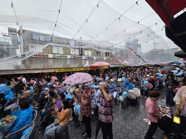 19일 수원시 장안구 반딧불이연무시장을 찾은 시민들이 트로트 공연을 즐기고 있다. [사진=김지호 기자]