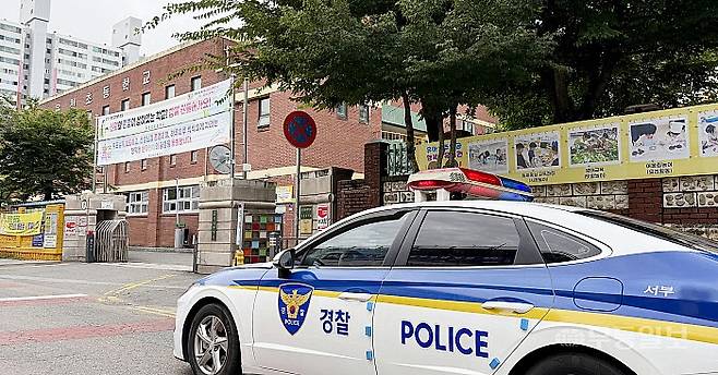 19일 오전 8시께 광주 서구 치평동 운천초등학교. 정문 앞에 순찰차 한 대가 세워져 있는 모습.