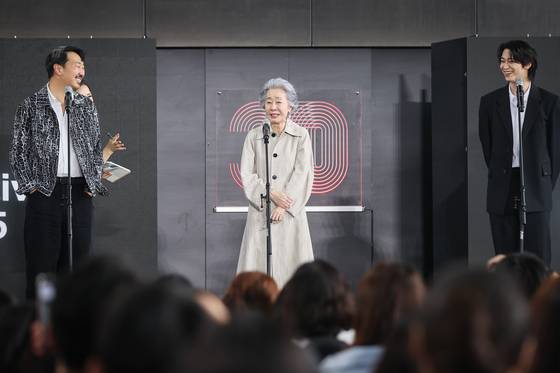 월드시네마 섹션에 공식 초청 된 영화 '결혼 피로연'으로 제30회 부산국제영화제를 찾은 앤드류 안 감독과 배우 윤여정 한기찬이 19일 부산 해운대구 우동 영화의 전당에서 열린 프로텍터 야외무대인사에서 관객들에게 인사하고 있다. 〈사진=연합뉴스〉