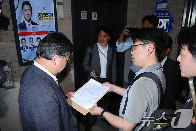 국민의힘 당원명부 압수수색에 나선 김건희특검 수사관들이 18일 서울 여의도 중앙당사에서 국민의힘 변호사에게 영장을 제시하고 있다. 2025.9.18/뉴스1 ⓒ News1 신웅수 기자